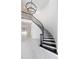 Elegant curved staircase with black railing and chandelier at 10055 Brocksport Cir, Gotha, FL 34734