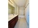 Bathroom with double sinks, large mirror, shower-tub, and white tile at 1183 Chervil Dr, Poinciana, FL 34759