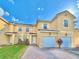 Inviting townhome exterior with a red brick driveway, two garages, and terracotta roof tiles at 1183 Chervil Dr, Poinciana, FL 34759