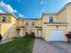 Inviting two-story townhome with neutral stucco, white trim, shutters, and a one car garage at 1183 Chervil Dr, Poinciana, FL 34759