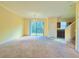 Spacious living room with neutral carpet, adjoining kitchen, and natural light at 1183 Chervil Dr, Poinciana, FL 34759