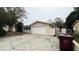 Spacious driveway leading to a two-car garage with an adjacent gated area at 1201 S Oxalis Ave, Orlando, FL 32807