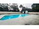 Backyard pool with an adjacent shed surrounded by privacy wall and mature trees at 1201 S Oxalis Ave, Orlando, FL 32807