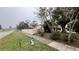 Quiet residential street view of a home, featuring a sidewalk and lush landscaping at 1201 S Oxalis Ave, Orlando, FL 32807