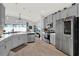 Modern kitchen with gray cabinetry, stainless steel appliances, breakfast bar, and a view of the living area at 1204 Pando Loop, Orlando, FL 32824