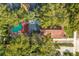 Aerial view of a home with a red roof, a pool, and surrounded by lush trees at 122 N Hyer Ave, Orlando, FL 32801