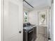 A laundry room featuring a washer, dryer and utility sink with a window at 122 N Hyer Ave, Orlando, FL 32801