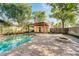 Beautifully landscaped backyard featuring a refreshing pool, brick patio, and fire pit area at 122 N Hyer Ave, Orlando, FL 32801