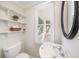 Cozy powder room featuring open shelving, classic fixtures, and a window for natural light at 122 N Hyer Ave, Orlando, FL 32801