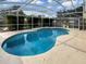 Inviting kidney-shaped pool, enclosed by a screen for year-round enjoyment, within a well-maintained backyard at 13842 Belvin Ct, Orlando, FL 32826