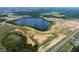 An aerial view showcasing a lake, green spaces, and the beginning stages of a residential community at 16863 Muskgrass Dr, Winter Garden, FL 34787