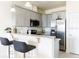 Contemporary kitchen featuring a breakfast bar, stainless steel appliances, and stylish cabinetry at 1772 Coriander Dr, Kissimmee, FL 34759