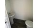 Small bathroom includes pedestal sink, dark wood floors and a water closet at 1926 Golden Beak Dr, Eagle Lake, FL 33839