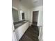 Bright bathroom featuring double vanity, granite countertops, and stylish dark wood flooring at 1926 Golden Beak Dr, Eagle Lake, FL 33839