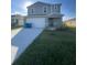 Two-story home with gray siding, a two-car garage, and a well-maintained lawn at 1926 Golden Beak Dr, Eagle Lake, FL 33839