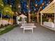 Large backyard with ping pong, guest house, and lounge area illuminated by string lights and mature trees at 1932 Temple Dr, Winter Park, FL 32789