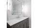 Elegant bathroom featuring a gray vanity with a white countertop, a large mirror, and modern lighting fixtures at 1932 Temple Dr, Winter Park, FL 32789