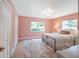 Sunlit bedroom with pink walls, wood floors, a plush rug, and dual windows overlooking the yard at 1932 Temple Dr, Winter Park, FL 32789