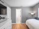 Neutral bedroom featuring light wood floors and gray walls, complete with TV, closet, and adjacent bathroom at 1932 Temple Dr, Winter Park, FL 32789