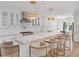 Bright kitchen boasts a large island with marble countertop and seating under stylish pendant lights at 1932 Temple Dr, Winter Park, FL 32789