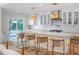 Bright kitchen boasts a large island with marble countertop and seating under stylish pendant lights at 1932 Temple Dr, Winter Park, FL 32789