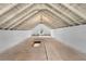 Unfinished attic space showcasing exposed beams and natural light through a window at 202 Division, Deland, FL 32720