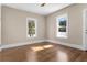 Cozy bedroom showcasing gleaming hardwood floors and natural light from the windows at 202 Division, Deland, FL 32720