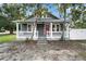 Charming gray home with a cozy front porch and red front door at 202 Division, Deland, FL 32720