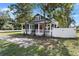 Inviting home features a gray exterior, red door, and classic front porch at 202 Division, Deland, FL 32720