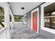 Covered front porch featuring gray tile flooring and a red front door at 202 Division, Deland, FL 32720