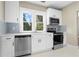 Modern kitchen boasts stainless steel appliances, white cabinets, and natural light at 202 Division, Deland, FL 32720