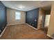 Neutral bedroom with plush carpet, large window, and stylish accent wall at 2523 Econ Landing Blvd, Orlando, FL 32825