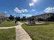 Open community park featuring a playground, covered picnic area, and lush green spaces under a blue sky at 2523 Econ Landing Blvd, Orlando, FL 32825