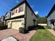 Exterior view of the home with a two-car garage and lush landscaping at 2523 Econ Landing Blvd, Orlando, FL 32825