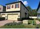 Exterior view of the home with a two-car garage and lush landscaping at 2523 Econ Landing Blvd, Orlando, FL 32825