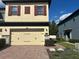 Charming two-story home featuring red shutters and a brick driveway leading to a two-car garage at 2523 Econ Landing Blvd, Orlando, FL 32825