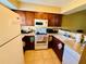 Functional kitchen featuring wood cabinets, white appliances, and ample counter space at 282 Scottsdale Sq # 282, Winter Park, FL 32792