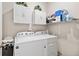 Bright laundry room featuring a white washer and dryer, white cabinets, and a storage shelf at 2857 Neverland Dr, New Smyrna Beach, FL 32168