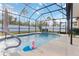 Sparkling screened pool features a rock waterfall, lush landscaping, and privacy at 2857 Neverland Dr, New Smyrna Beach, FL 32168