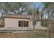 Exterior view of a backyard with mature trees, showcasing a patio and the rear of the house at 302 Bridie Ct, Winter Springs, FL 32708