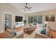 Bright living room featuring a ceiling fan, a large TV, and sliding glass doors at 302 Bridie Ct, Winter Springs, FL 32708