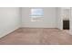 Bright bedroom featuring neutral carpeting, a large window, and ensuite bathroom at 360 Arbor Lakes Dr, Davenport, FL 33896