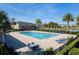 An aerial view of the community pool surrounded by palm trees and lounge chairs, providing a perfect resort-style relaxation space at 360 Arbor Lakes Dr, Davenport, FL 33896