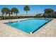 A refreshing community pool framed by palm trees and lounge chairs, providing a perfect spot for relaxation and leisure at 360 Arbor Lakes Dr, Davenport, FL 33896