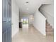 Bright entryway with tile flooring and staircase with a view to the backyard at 360 Arbor Lakes Dr, Davenport, FL 33896