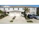 Townhome's exterior featuring a two-car garage, well-kept lawn, and modern architectural style at 360 Arbor Lakes Dr, Davenport, FL 33896