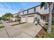 Exterior view of a townhome with a two-car garage, landscaped yard, and a palm tree at 360 Arbor Lakes Dr, Davenport, FL 33896