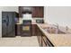 View of kitchen with stainless steel appliances, neutral countertops, and dark wood cabinets at 360 Arbor Lakes Dr, Davenport, FL 33896