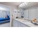 Bathroom with double vanity, granite countertops, and white cabinets adjacent to a bedroom at 3926 Lana Ave, Davenport, FL 33897