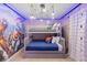 Fun ' bedroom with superhero mural and a gray bunkbed with blue bedding and decorative pillows at 3926 Lana Ave, Davenport, FL 33897